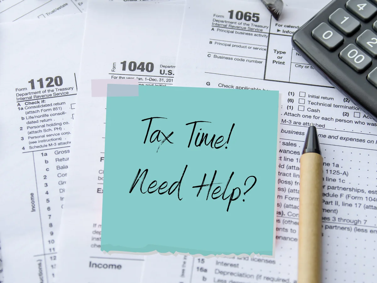 Business tax forms with a Tax Time Need Help note
